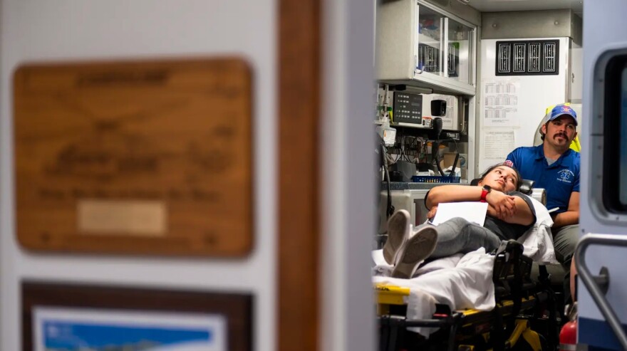 Instructor Doug Anderson works with students in the back of an ambulance while Sabrina Rodriguez, playing the part of a patient, lays on the gurney during an EMT certification class at the Olton Volunteer Ambulance Association.