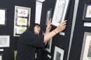 Jocelyn Wellings hangs paintings in preparation for the 2019 Summerfest Arts Faire at the Logan Tabernacle.