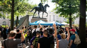 Counter-protestors raise their fists at Freedom Plaza as supporters of those charged in the January 6 attack on the U.S. Capitol attend the Justice for J6 rally near the U.S. Capitol in Washington, DC.