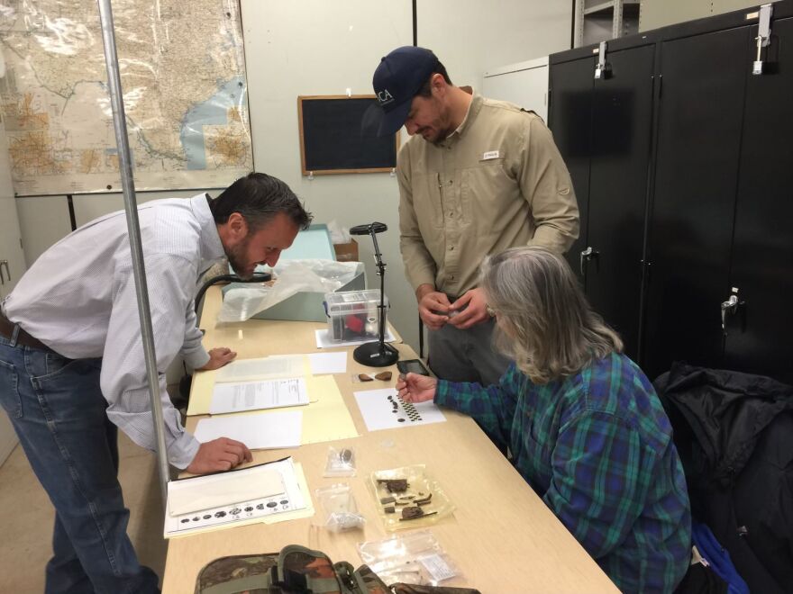 Researchers examine items from the battle.