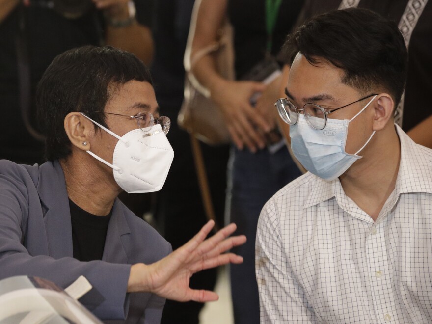 Rappler CEO and Executive Editor Maria Ressa (left) talks with former Rappler reporter Reynaldo Santos Jr. during a news conference in Manila on Monday.