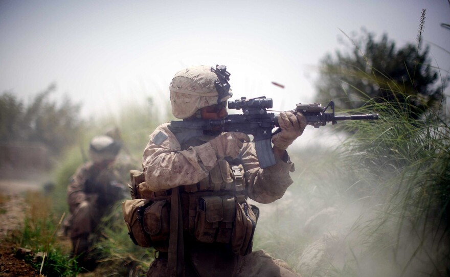 A U.S. Marine from the 2nd Marine Expeditionary Brigade, RCT 2nd Battalion, 8th Marines, Golf Company engages in a firefight on July 8, 2009, in Mian Poshteh, Afghanistan.