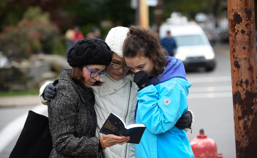 Tammy Hepps, Kate Rothstein and her daughter, Simone Rothstein, 16, pray from a prayerbook a block away from the site of a mass shooting at the Tree of Life Synagogue in the Squirrel Hill neighborhood.