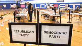 A voter checks in at Suffield Middle School on primary election day, Tuesday, Aug. 9, 2022, in Suffield, Conn. Suffield is one of several small towns in Connecticut where control was flipped from Democrats to Republicans in 2021 municipal races. (AP Photo/Jessica Hill)
