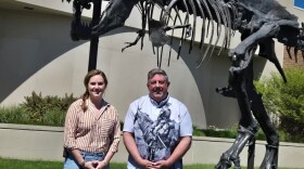 Kate Hodge (left), Director of Education and Public Programming, and Scott Williams, Senior Director of Exhibitions and Planetarium at Museum of the Rockies, stand in front of Big Mike, the bronze T-Rex statue that welcomes visitors to the museum.