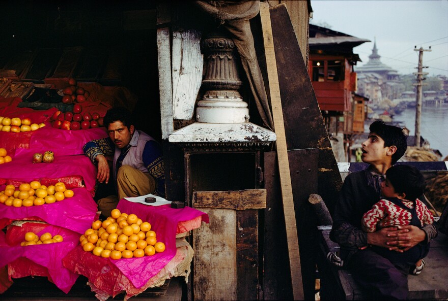 Fruit Seller and a boy with a child at Zaina Kadal Bridge, Jhelum River, Srinagar, Kashmir, 1979.