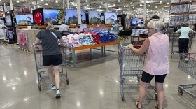 File - Shoppers push carts into a Costco warehouse Friday, Aug. 4, 2023, in Thornton, Colo. A surge in U.S. consumer spending is fueling economic growth, reflecting a resilience among households that has confounded economists, Federal Reserve officials and even the sentiments that Americans themselves have expressed in surveys. 