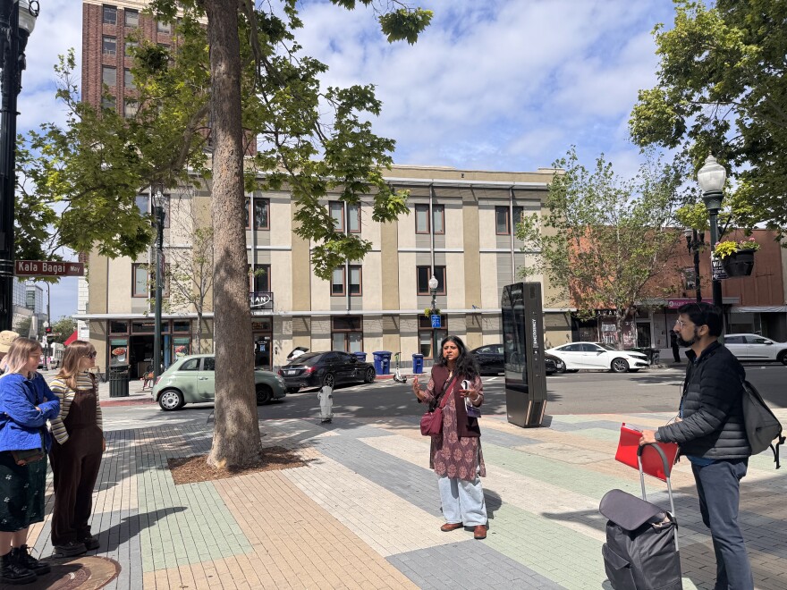 A woman in maroon Kurta stand at the intersection of Kala Bagai Way in Berkeley