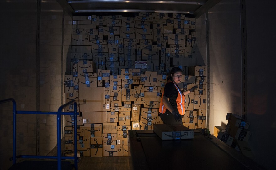 Amazon employee Andrea Neri stacks boxes in the back of a delivery truck on the ship dock at an Amazon fulfillment center on Friday, November 3, 2017, in Kent. 