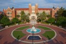 A large, brick building with a fountain in front of it