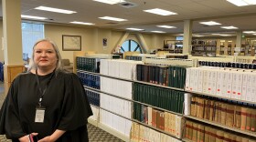 Crystal Hicks, head of collections at the Washington State Library, stands in the library's reading room in Tumwater. The public can come here to look at historic materials in the library's collection. That access could be limited as the library is having to lay off staff. (Credit: Lauren Gallup // NWPB)