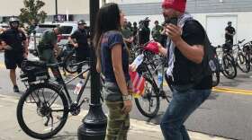 Protester Alexandra Ale and Trump supporter Gary Snow face off. Photo: Danielle Prieur, WMFE