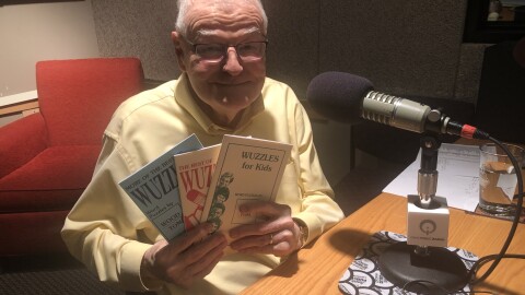 A man holds puzzle books