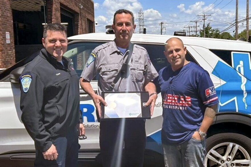 An undated photo shows Scott Montellaro, a paramedic field training officer at American Medical Response New Haven's offices. as he received an award for 30 years of service. Montellaro is in the middle, flanked from right to left by Dave Laspino, an AMR Paramedic Supervisor and Clinical Education Supervisor, and Michael Turcio an AMR Operations Manager, New Haven.