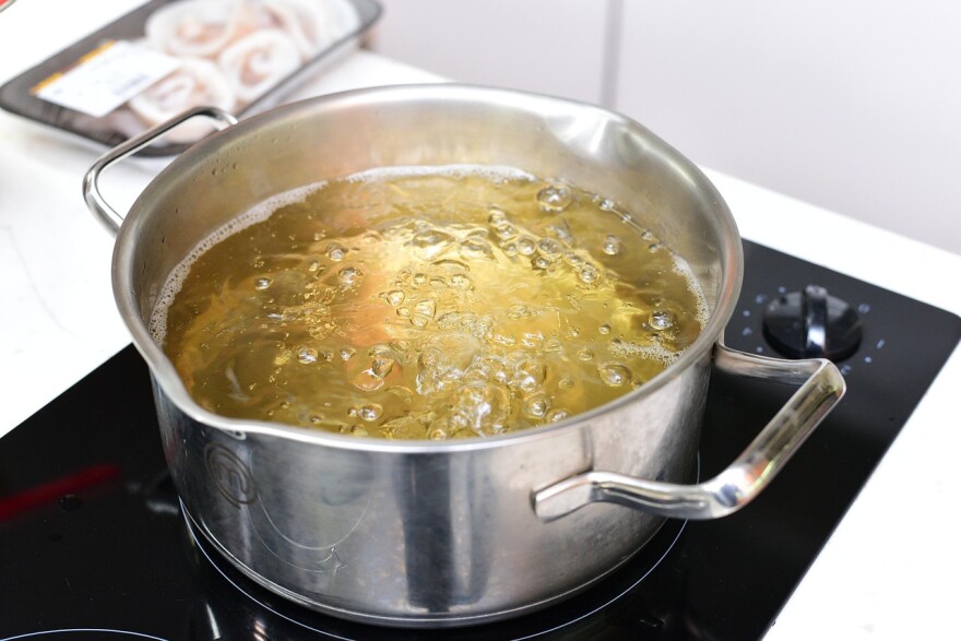 A pot on a stove begins to boil.