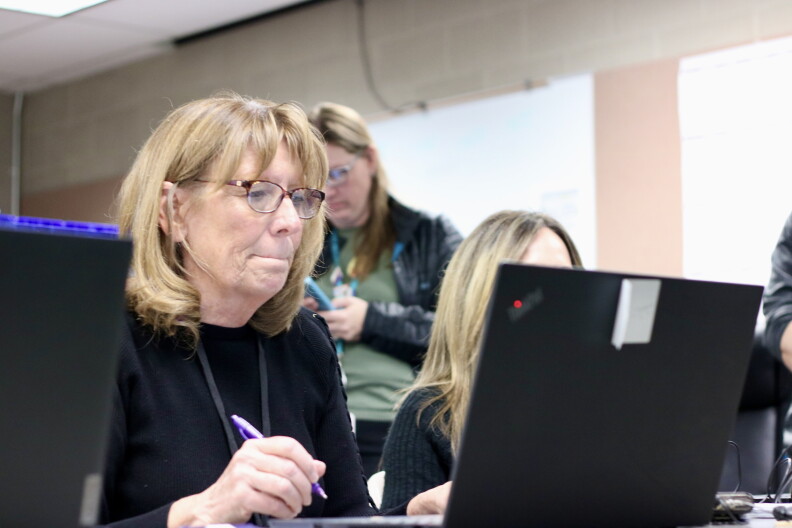 An election volunteer checks people in to vote at the Jefferson County Jail.