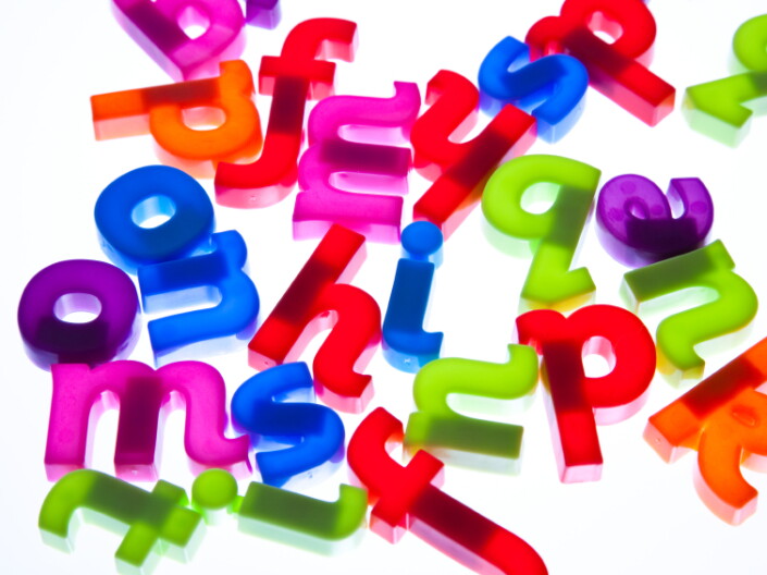 Colorful letters sit on a white background. 