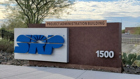 SRP building sign with blue letters on a brown wall background