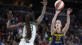 Indiana Fever's Caitlin Clark (22) shoots over Seattle Storm's Ezi Magbegor, left, during the first half of a WNBA basketball game, Sunday, Aug. 18, 2024, in Indianapolis. (AP Photo/Darron Cummings)