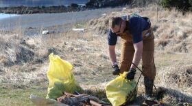 KODIAK, Alaska - Coast Guard Chief Petty Officer Jeremiah Moon, a boatswains mate with the North Pacific Regional Fisheries Training Center, ties a trash bag full of garbage collected from Jewel Beach May 6, 2011, on Coast Guard base Kodiak. The base took advantage of the weather and held their annual Earth Day cleanup.