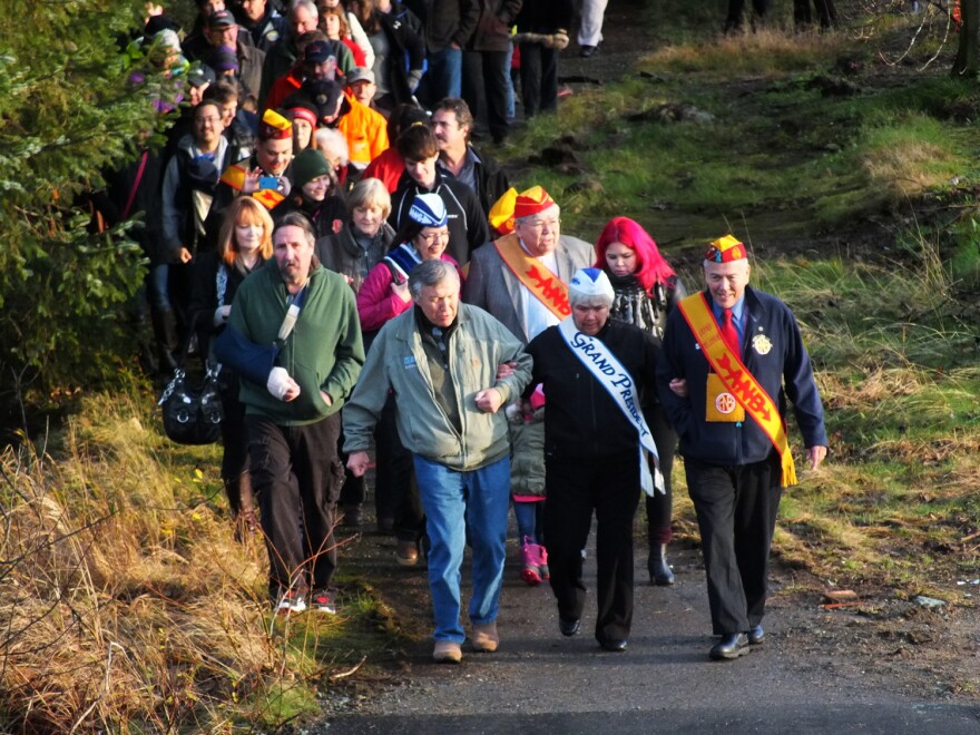 Roy Peratovich Jr. (from left at front), Alaska Native Sisterhood Grand President Johanna Dybdahl, and Alaska Native Brotherhood Grand President Sasha Soboleff lead the procession to the new Brotherhood Bridge that includes Peratovich’s family and transportation officials. (Photo by Matt Miller/KTOO)
