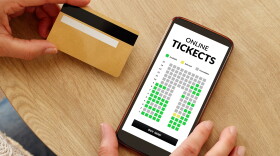 Close-up photo of female hands with credit card making mobile payment for event cinema tickets. Online show theater tickets booking.
