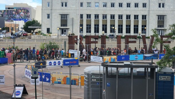 A large group of people can be seen standing in line behind the set up of Rollin' Reno
