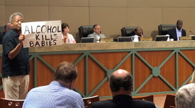 Man holds up a sign during the Monday CRA meeting