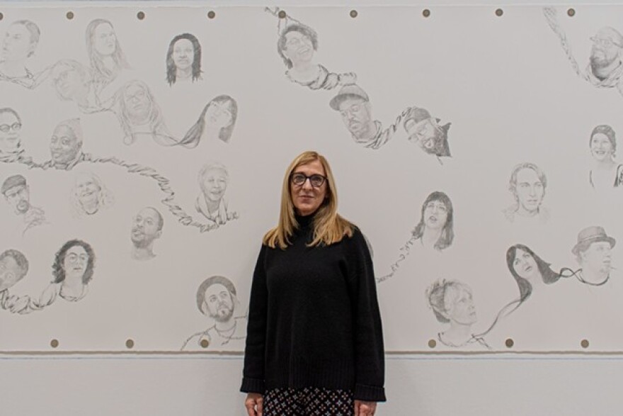 Susan Begy stands in front of her mural "Entanglement" at Rochester Contemporary Art Center.