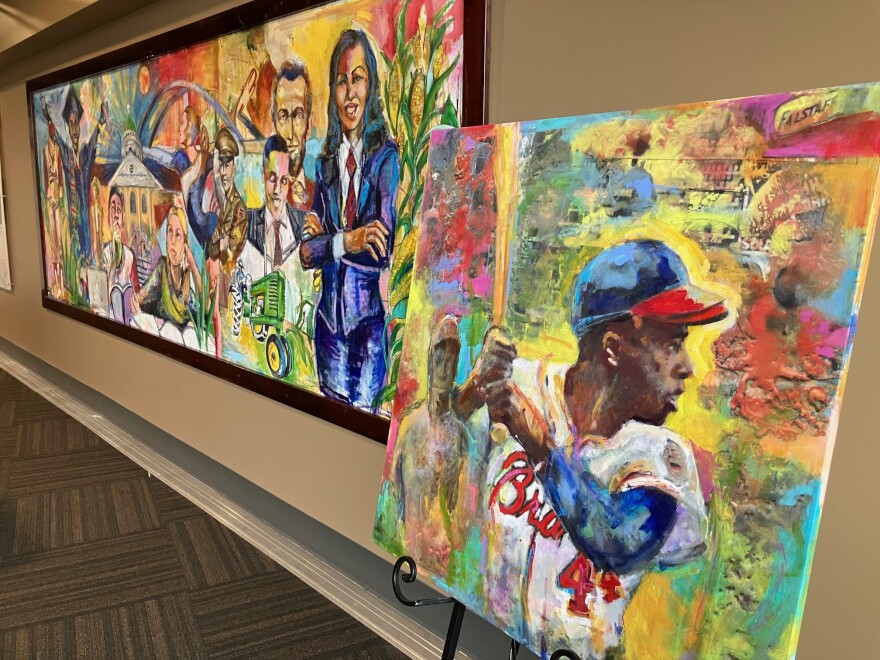 Preston Sampson's Hank Aaron painting (right, done in 2015), stands next to his permanent Quad Cities mural at Modern Woodmen Park's Diamond Club, March 26, 2026.