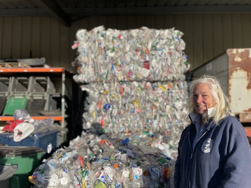 Denise Cumings, crew chief, stands in front of a bale of recycling at the Hooksett Transfer Station