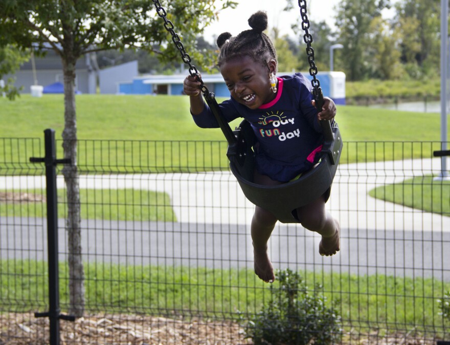 Kiana King, 2, enjoys rocking back and forth on a swing set at Depot Park, located near downtown Gainesville. The park's successful decade-plus redevelopment of the area's downtown evolution. "She always loves coming here for the swings," said Calvin King, Kiana's dad, who came along with her to the park. (Adrian Casaretto/WUFT News)