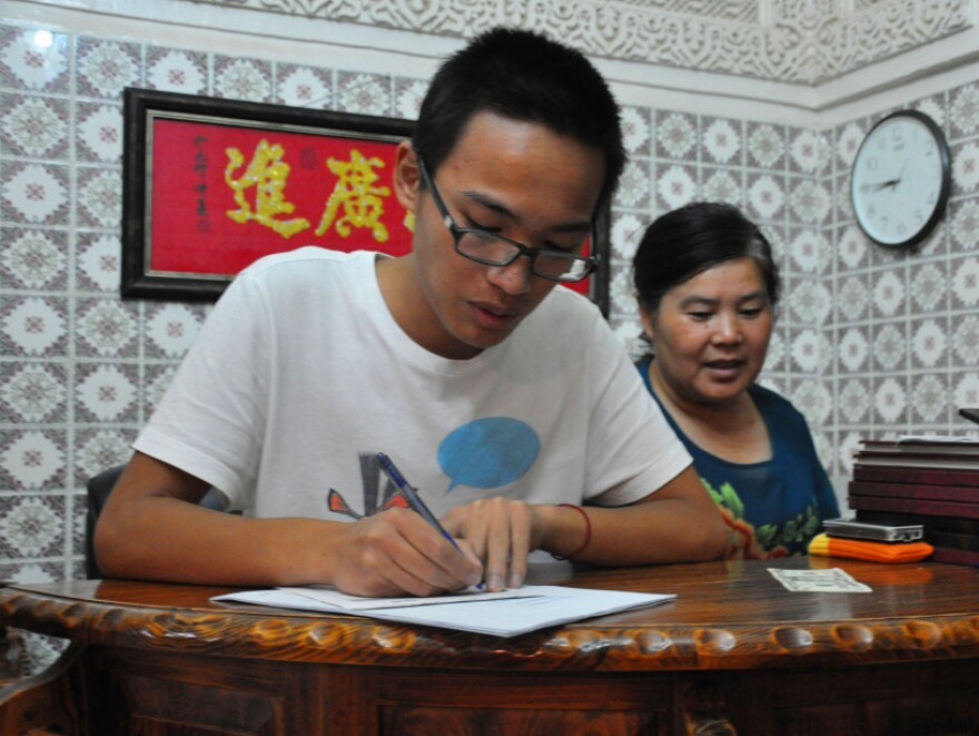 Dai Songxian (right) and her son, Alex, take a food order. They run the only remaining Chinese restaurant in Tripoli, as fighting has caused other foreigners to flee.