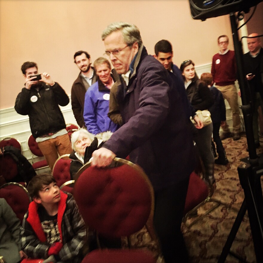 Bush helps put out additional chairs at his final New Hampshire town hall in Portsmouth on Monday evening.