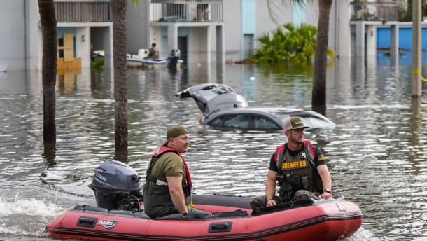 A water rescue boat moves in floodwaters at an apartment complex  