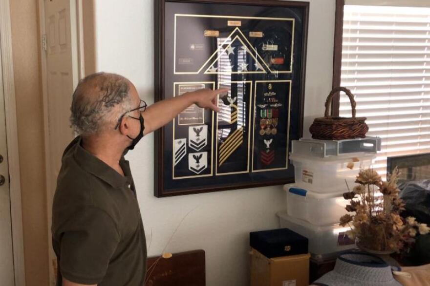 Veteran Marc Session points to some of his Navy mementos on display in his Chula Vista, California home.