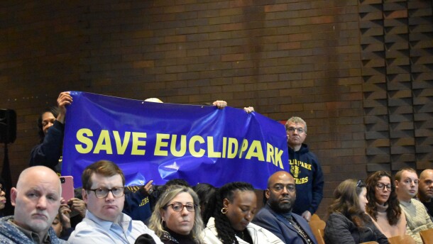 Community members hold a banner asking Cleveland Metropolitan School District to not close their school, Euclid Park on the city's Northeast Side.