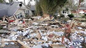 FILE - Moe Llaren makes his way through the debris of destroyed homes as he tries to find his own house in Gulfport, Miss., on Aug. 31, 2005. (AP Photo/Denis Paquin, File)