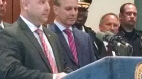 RPD Officer Luca Martini (L) and Attorney General Eric Schneiderman (R) at podium