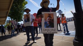 Farmworkers in Yakima’s fruit-packing industry walked off production lines in May and went on strike, demanding more protections against the coronavirus pandemic. Above, Emmanuel Anguiano-Mendoza (left) and Agustin López hold posters featuring David Cruz, a worker who died on May 30. CREDIT: Enrique Pérez de la Rosa/NWPB