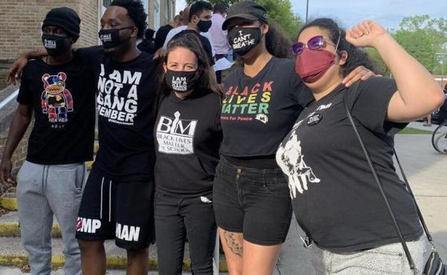 Amy Donofrio (center) and former students stand outside Robert E. Lee High. Donofrio is wearing a shirt that reads "Black Lives Matter at school." She was reassigned to non-teaching duties after refusing to take down a Black Lives Matter flag she had put up outside her classroom.