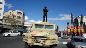 A member of police special forces stands guard on top their car at the Enqelab-e-Eslami, or Islamic Revolution, square in downtown Tehran, Iran, Monday, March 30, 2026. (AP Photo/Vahid Salemi)
