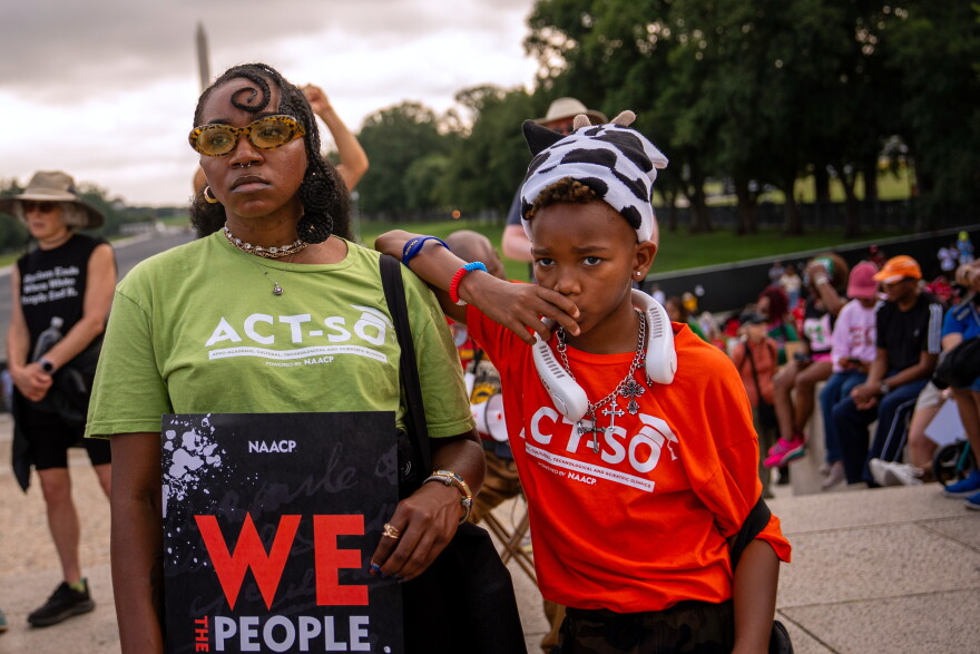 Demonstrators listen to speakers during the March on Washington, Friday, Aug. 28, 2026, near the Lincoln Memorial in Washington. (AP Photo/Julia Demaree Nikhinson)
