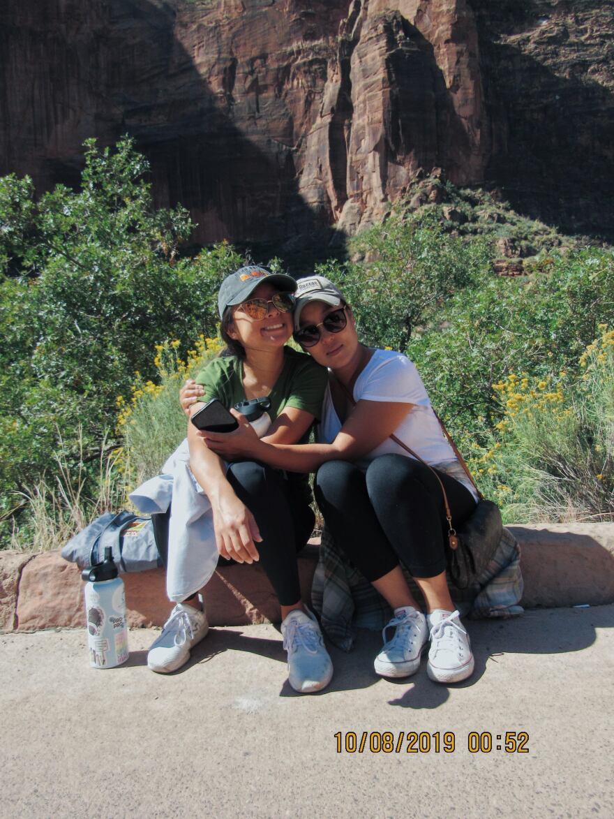 Women sitting and hugging each other.