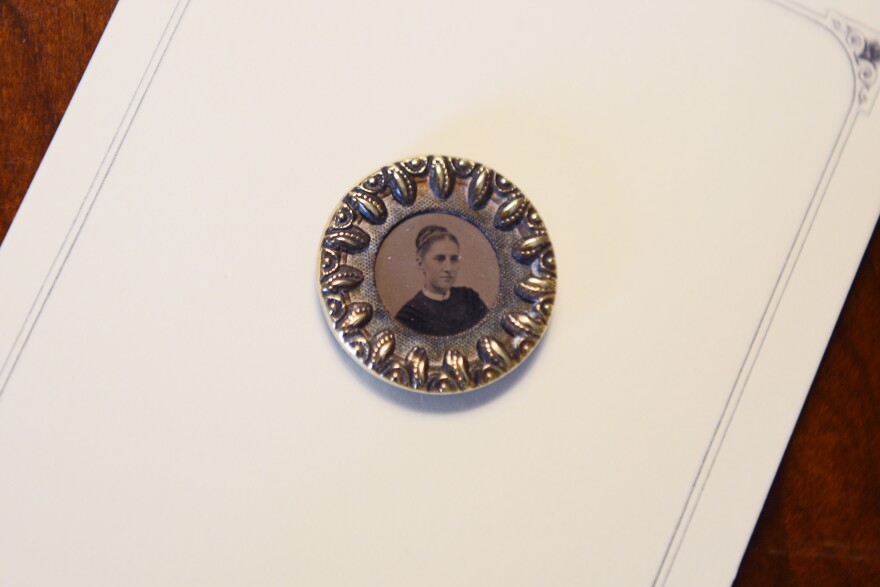 Close up of a metal button with an image of a woman in the center