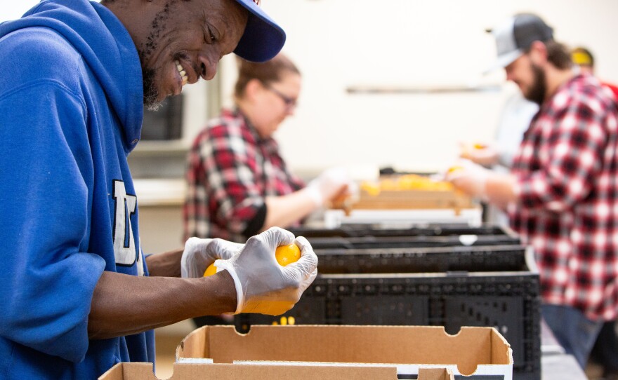 A picture of Rick Lewis inspecting produce.