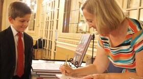 Local author Amanda Doyle signs a copy of one of her books for Charlie Wunderlich, 8, at the Missouri Athletic Club after the STL Storytelling Live event Aug. 29.