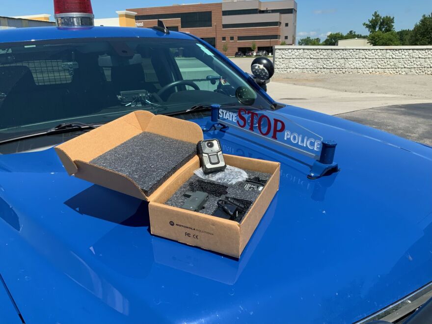 A body camera on display on top of a Michigan State Police cruiser.