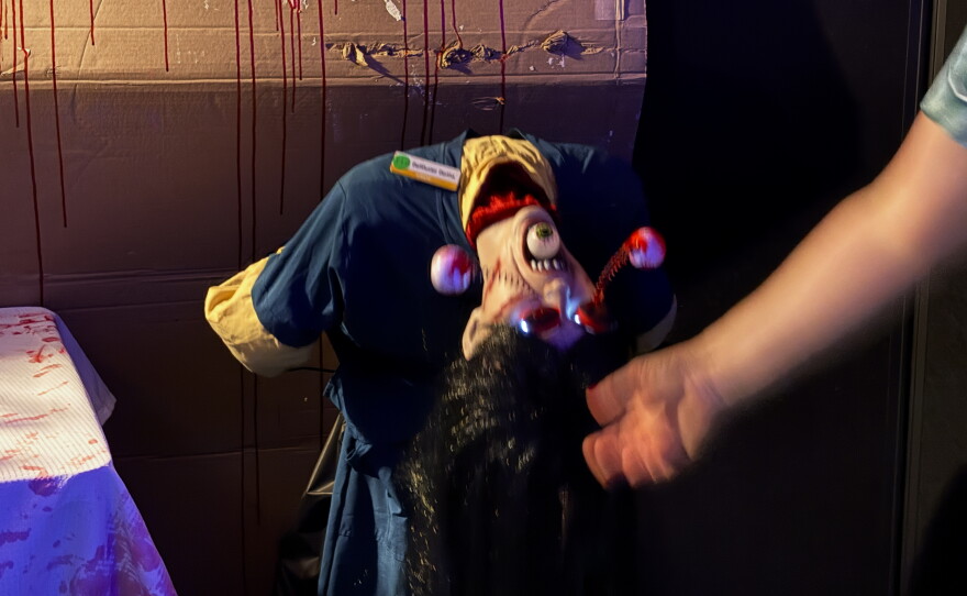Animatronic Nurse bending over backwards. Her eyes are out of the sockets.