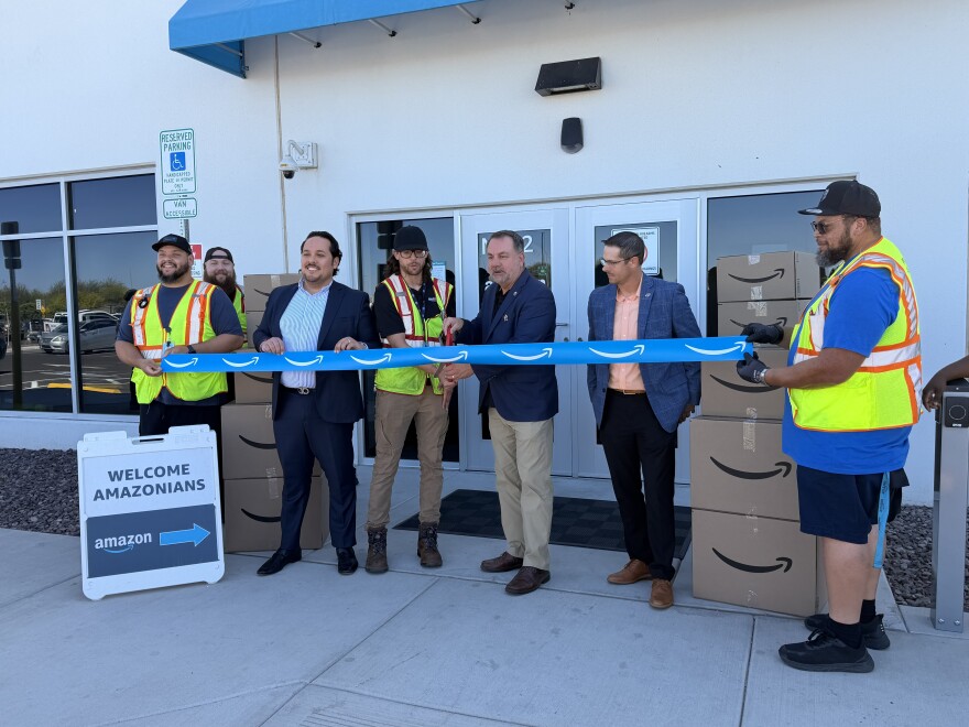 Amazon officials including Yuma delivery station manager Brian Willis, fourth from left, and Yuma Mayor Doug Nicholls hold a ribbon cutting ceremony on Thursday, March 19, 2026.
